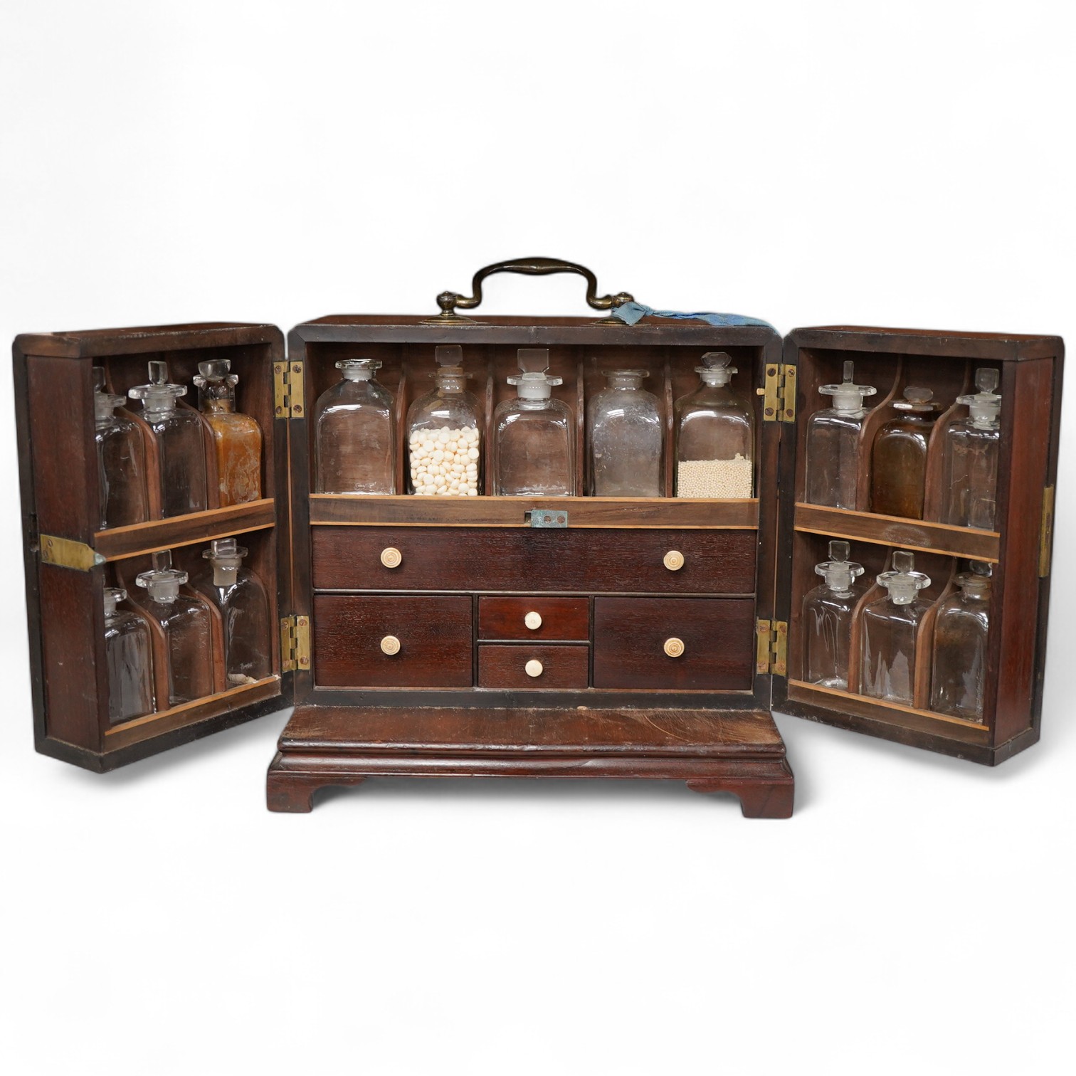 A 19th century mahogany apothecary cabinet, interior with fitting compartments containing twenty-one glass bottles, most with stoppers, five drawers with ivory knobs containing a miniature pestle and water, mixing glasse